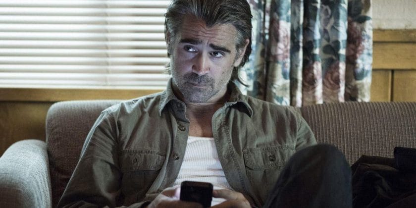 Colin Farrell on the couch with his phone in True Detective