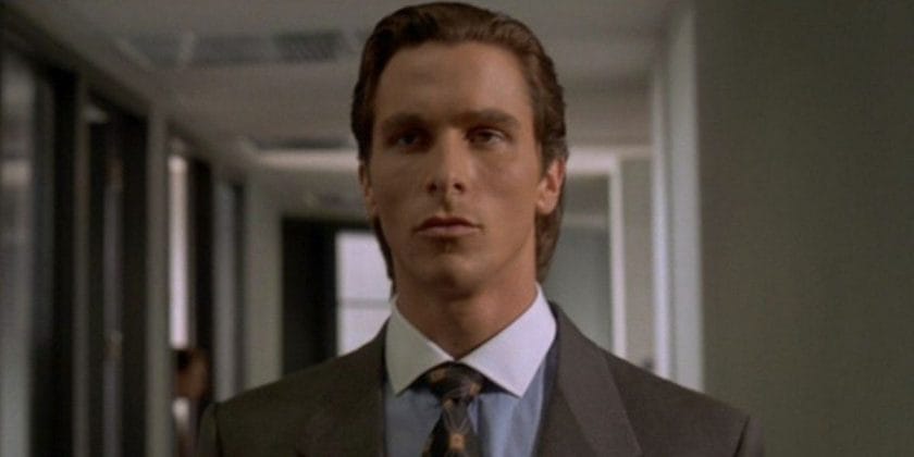 Patrick Bateman walking down the halls of his office lost in thought in American Psycho