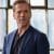 Damien Lewis as Bobby looking to his side in a blue coat in Billions